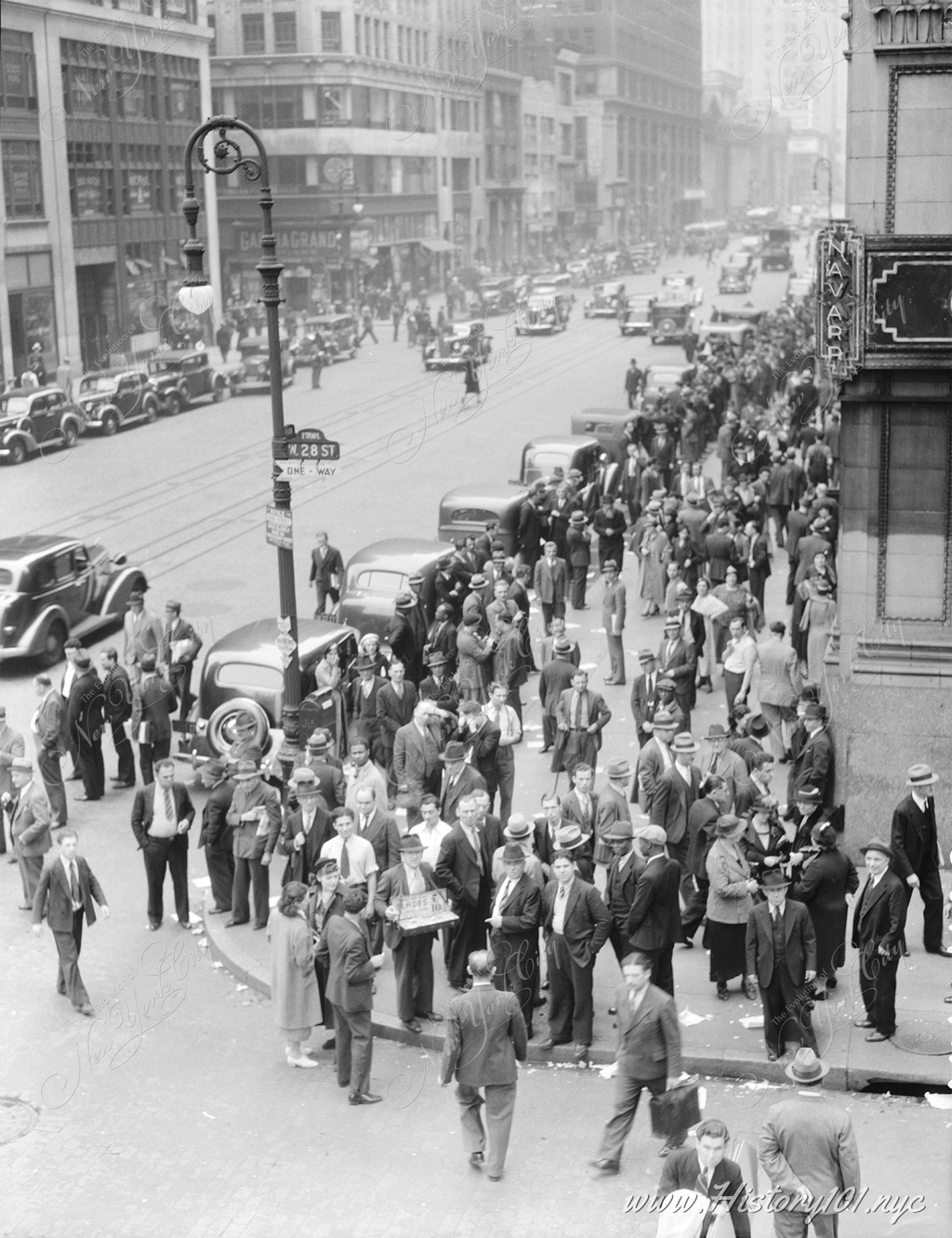 Elevated view of garment workers leaving factories for noon hour at the intersection of 7th Avenue and West 28th Street, Manhattan.